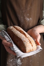Photo of Woman holding one freshly baked bread, closeup