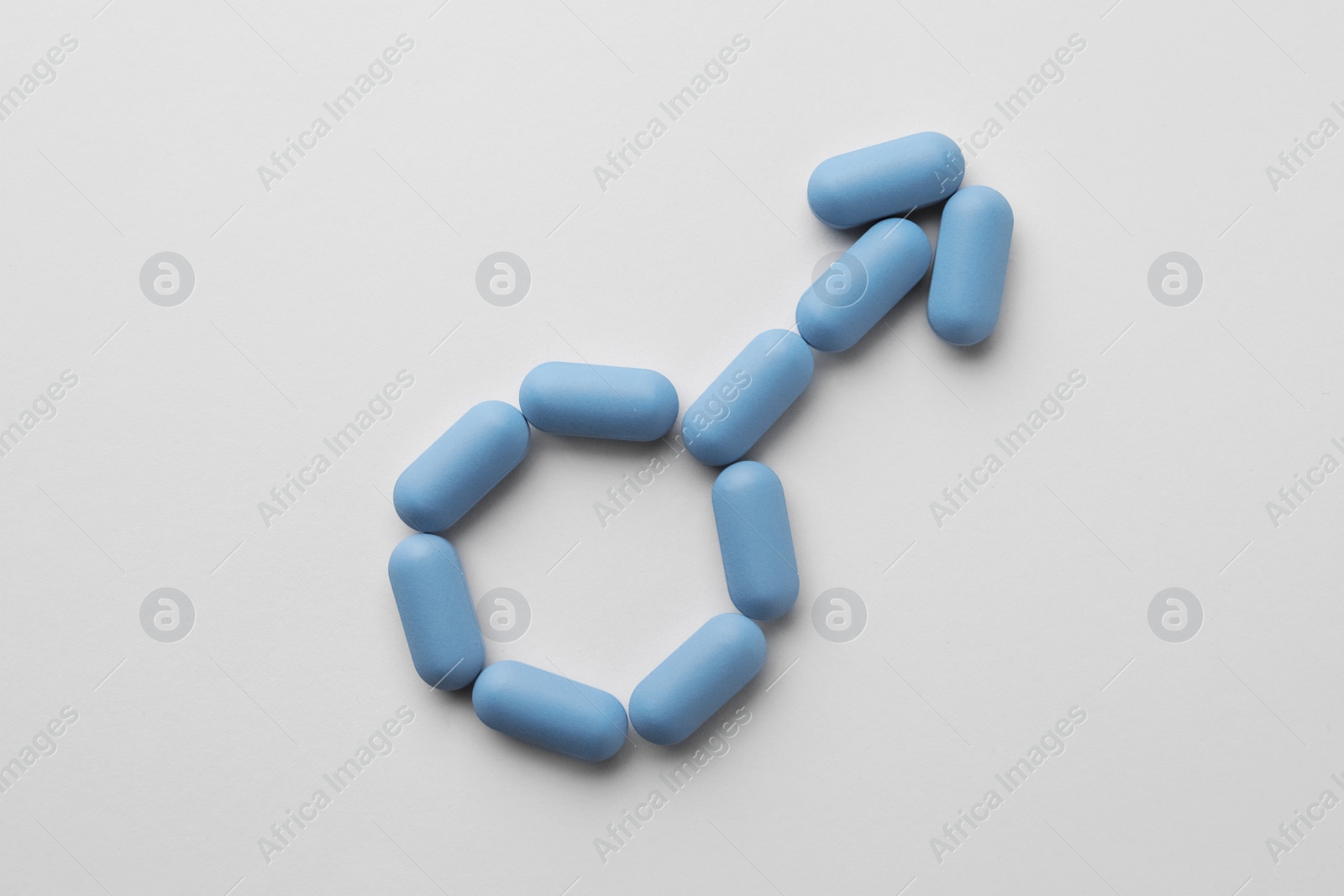 Photo of Male sign made of pills on white background, top view. Potency problem