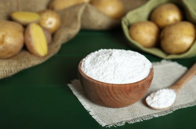 Photo of Starch and fresh raw potatoes on green wooden table. Space for text