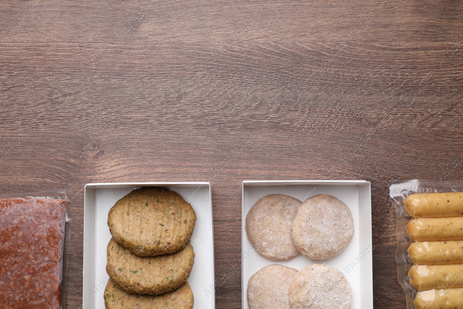 Photo of Different vegan products on wooden table, flat lay. Space for text