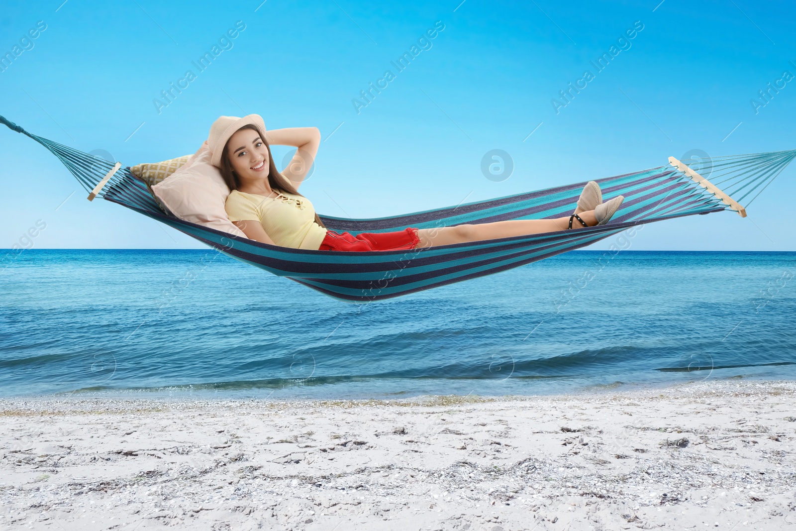 Image of Woman resting in hammock near sea on sunny day 