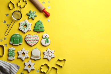 Flat lay composition with delicious gingerbread cookies and kitchen items on yellow background. Space for text
