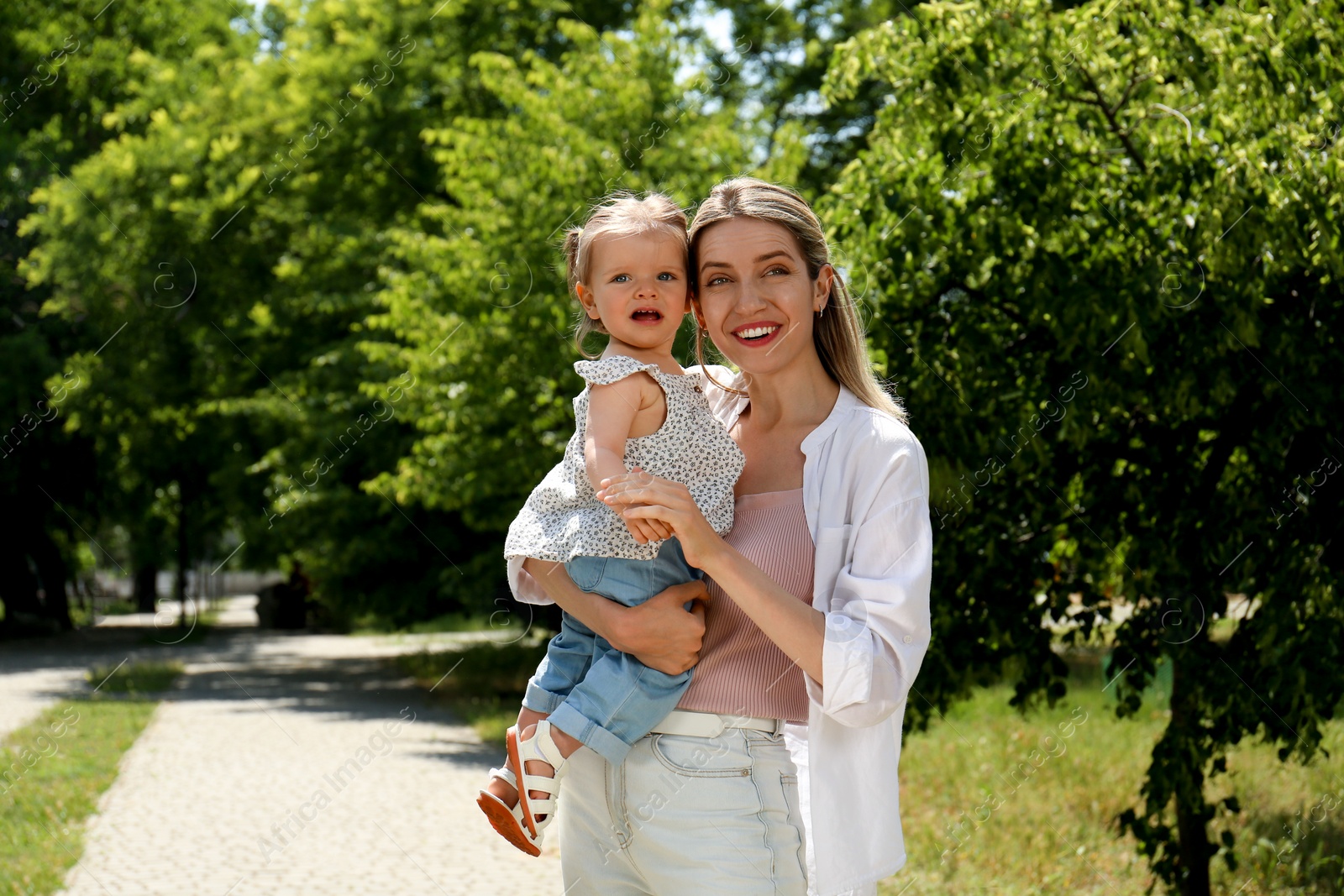 Photo of Happy mother with her daughter spending time together in park. Space for text