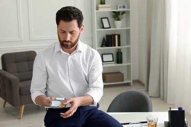 Photo of Man taking cigarette from case in office, space for text