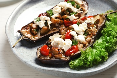 Plate with tasty stuffed eggplants on light table