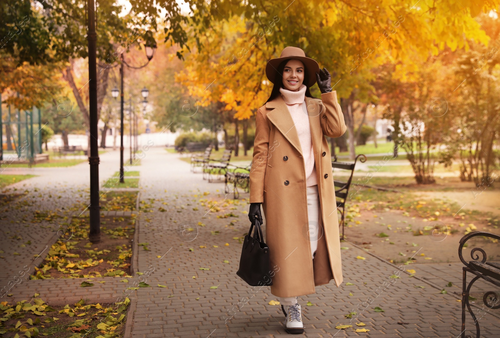 Photo of Young woman wearing stylish clothes in autumn park, space for text