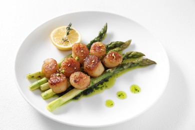 Photo of Delicious fried scallops with asparagus, lemon and thyme on white background