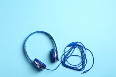 Photo of Stylish headphones on color background, top view. Space for text