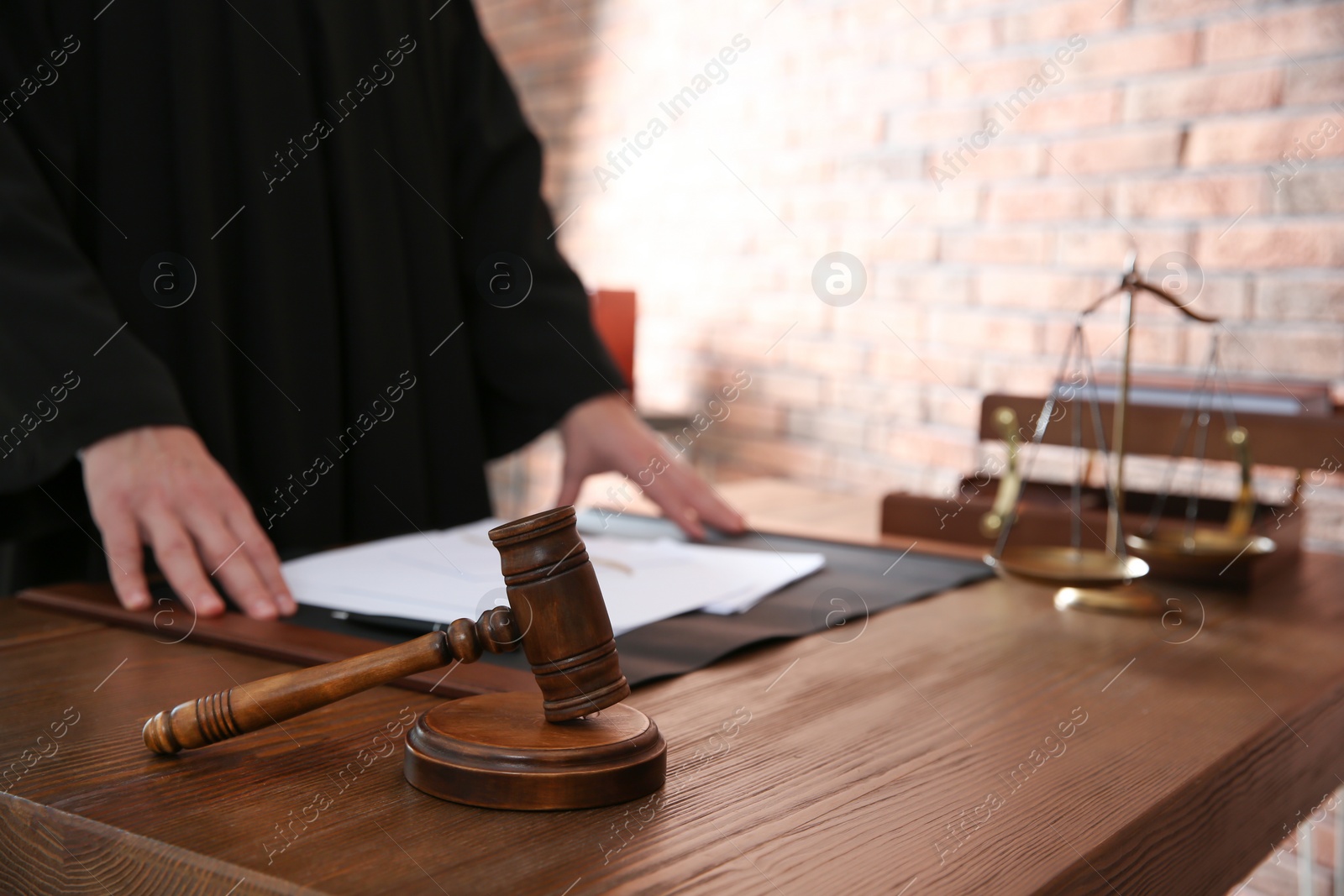 Photo of Judge with papers at table in office, closeup. Law and justice concept