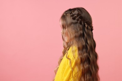 Cute little girl with braided hair on pink background. Space for text