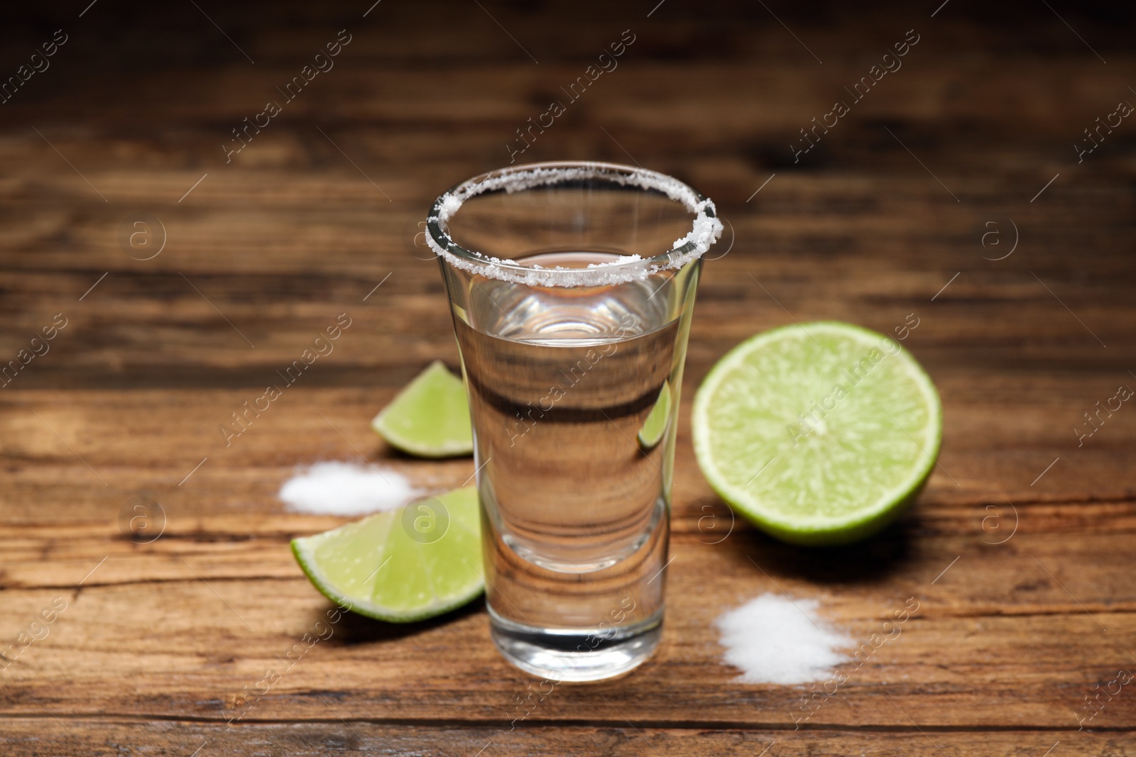 Photo of Mexican Tequila shot with salt and lime on wooden table