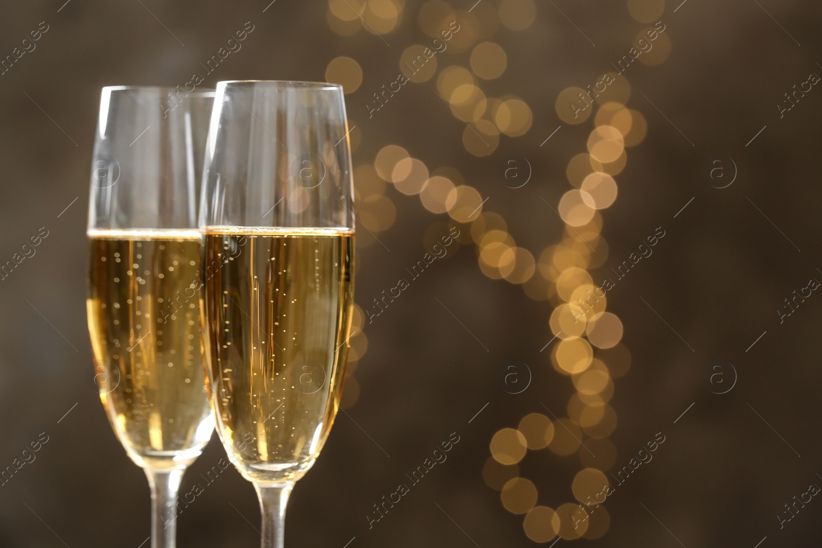 Photo of Glasses of champagne on blurred background, closeup. Space for text