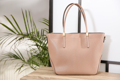 Photo of Beige woman's bag on wooden shelf in store