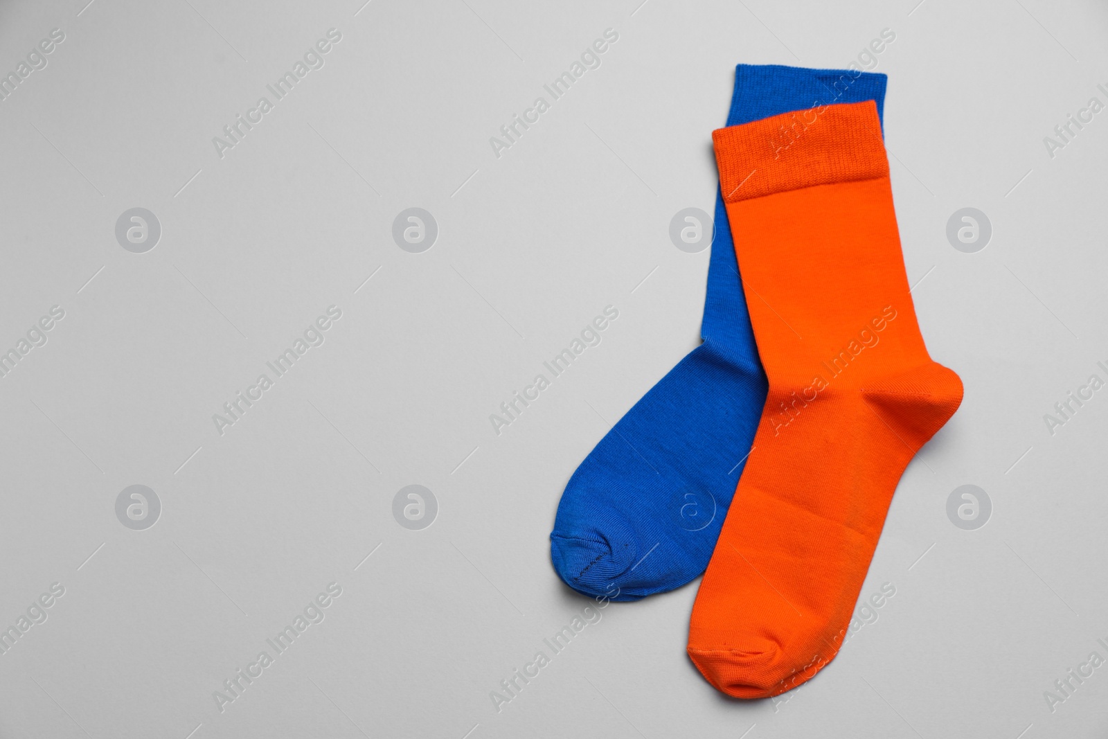 Photo of Colorful socks on light grey background, flat lay. Space for text