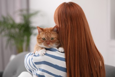 Photo of Woman with her cute cat at home, back view