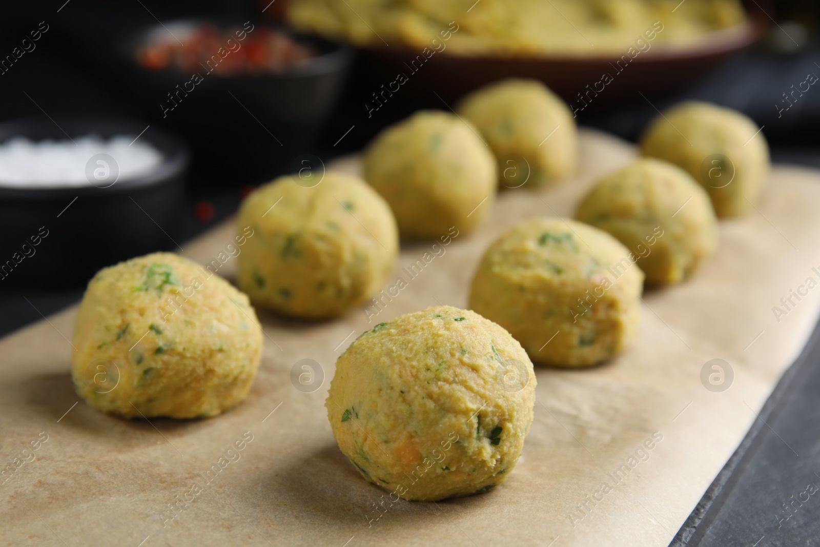 Photo of Raw falafel balls on black table, closeup