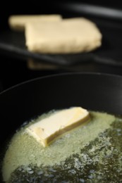 Photo of Melting butter in frying pan on table, closeup