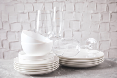 Photo of Set of clean dishware on marble table