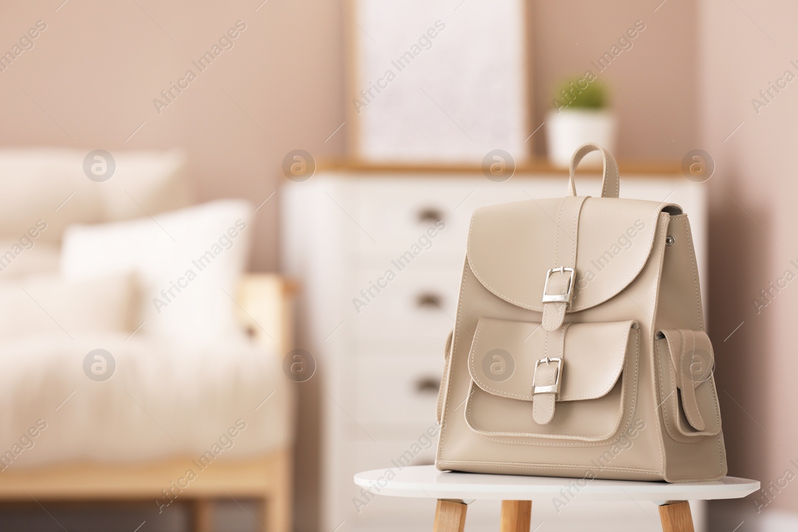 Photo of Stylish beige backpack on white table indoors, space for text