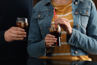 Photo of People holding glasses of cola with ice, closeup