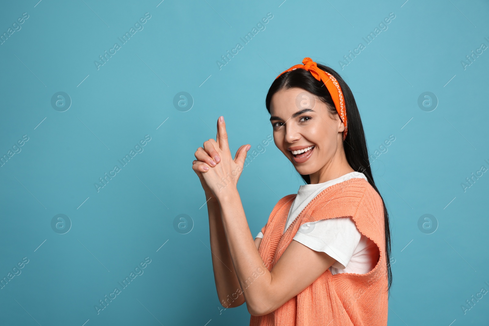 Photo of Young woman wearing stylish bandana on light blue background, space for text