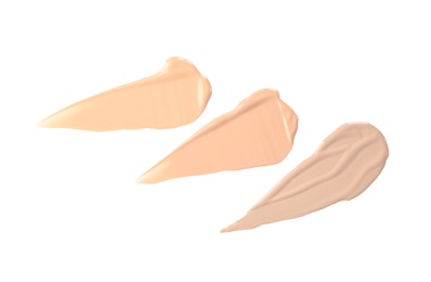 Photo of Samples of different foundation shades on white background, top view