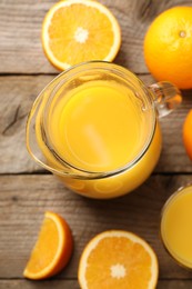 Photo of Tasty fresh oranges and juice on wooden table, flat lay