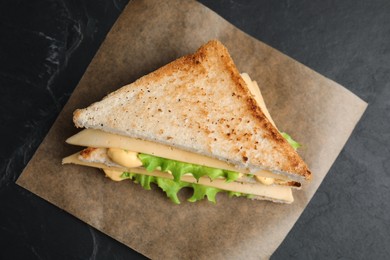 Photo of Fresh tasty cheese sandwich on black table, top view