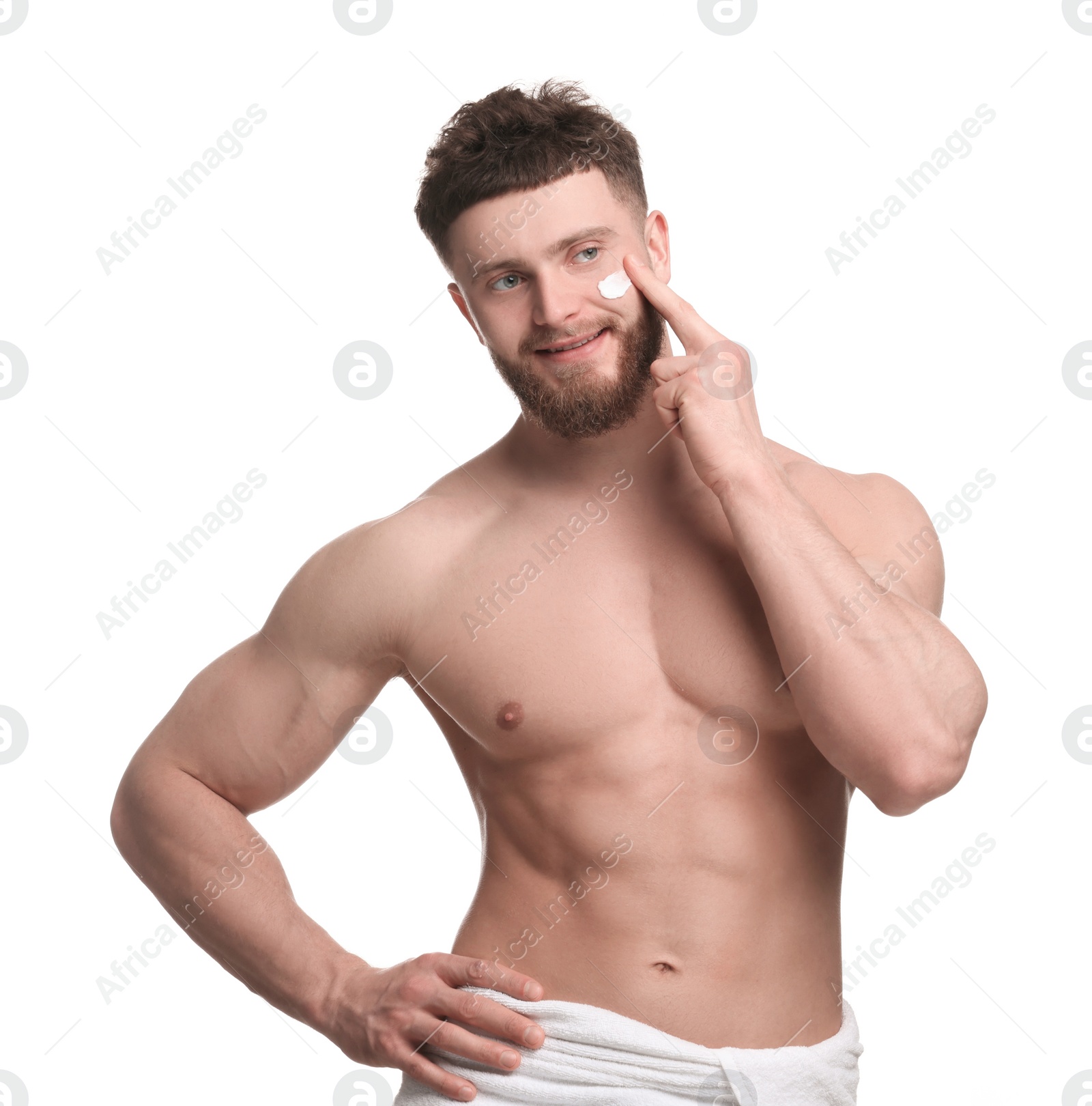 Photo of Handsome man applying moisturizing cream onto his face on white background