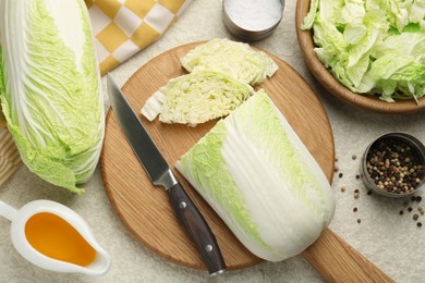 Photo of Fresh Chinese cabbages, oil and spices on light table, flat lay