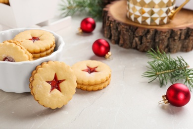 Traditional Christmas Linzer cookies with sweet jam and bowl on table
