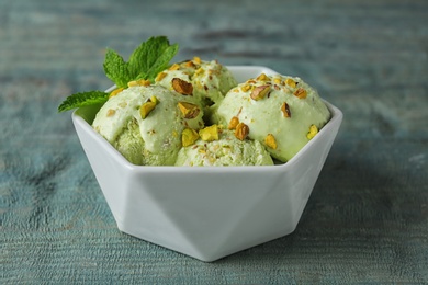 Photo of Delicious pistachio ice cream on blue wooden table