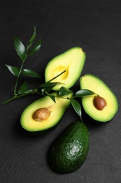 Fresh yummy avocado pieces on dark table