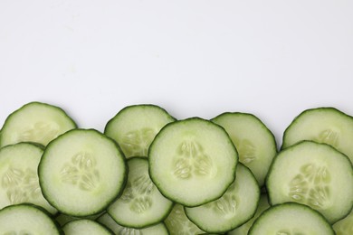 Fresh slices of cucumbers on white background, top view. Space for text