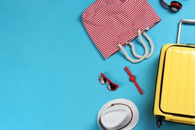 Photo of Flat lay composition with suitcase and accessories on color background, space for text. Summer vacation
