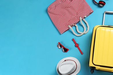 Flat lay composition with suitcase and accessories on color background, space for text. Summer vacation