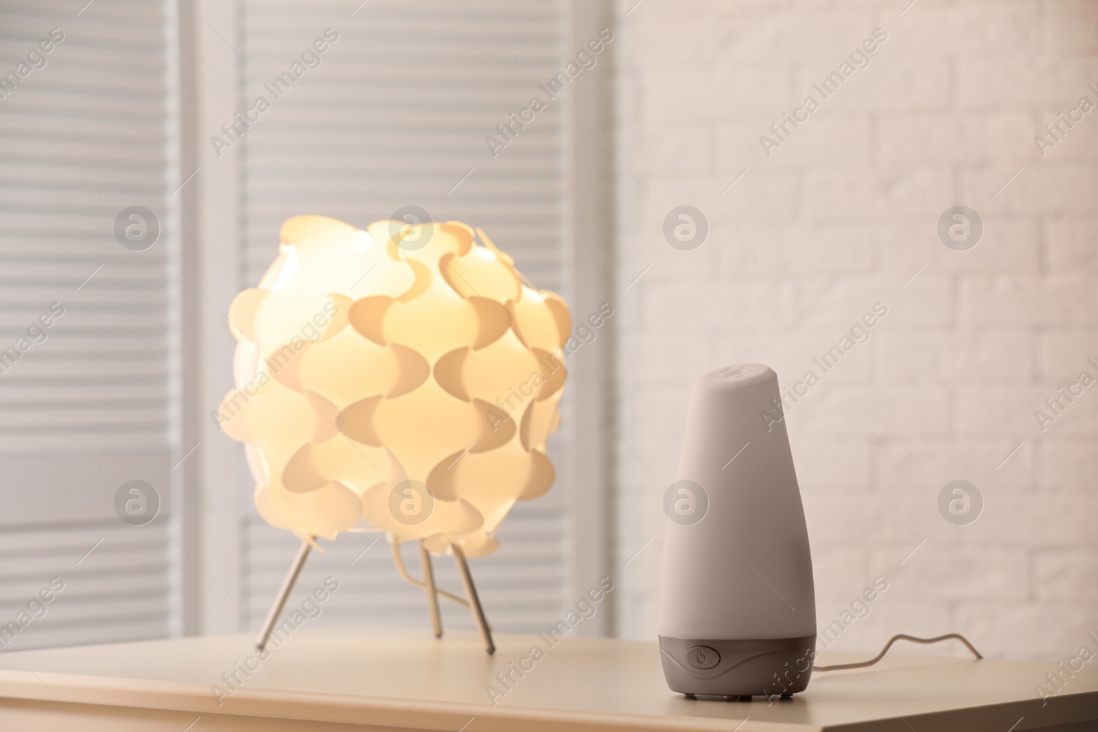 Photo of Modern essential oil diffuser on table indoors