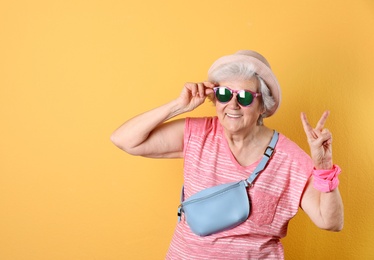 Photo of Portrait of cool grandmother on color background, space for text