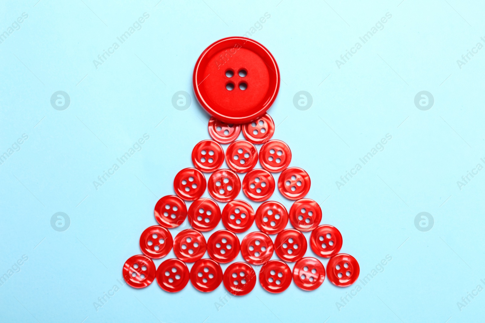 Photo of Christmas tree made with red buttons on light blue background, flat lay