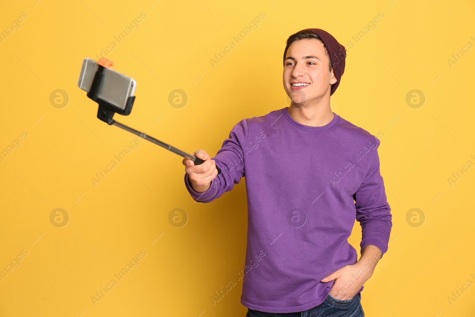 Photo of Young handsome man taking selfie against color background