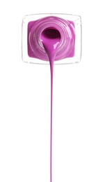 Pouring color nail polish from bottle on white background