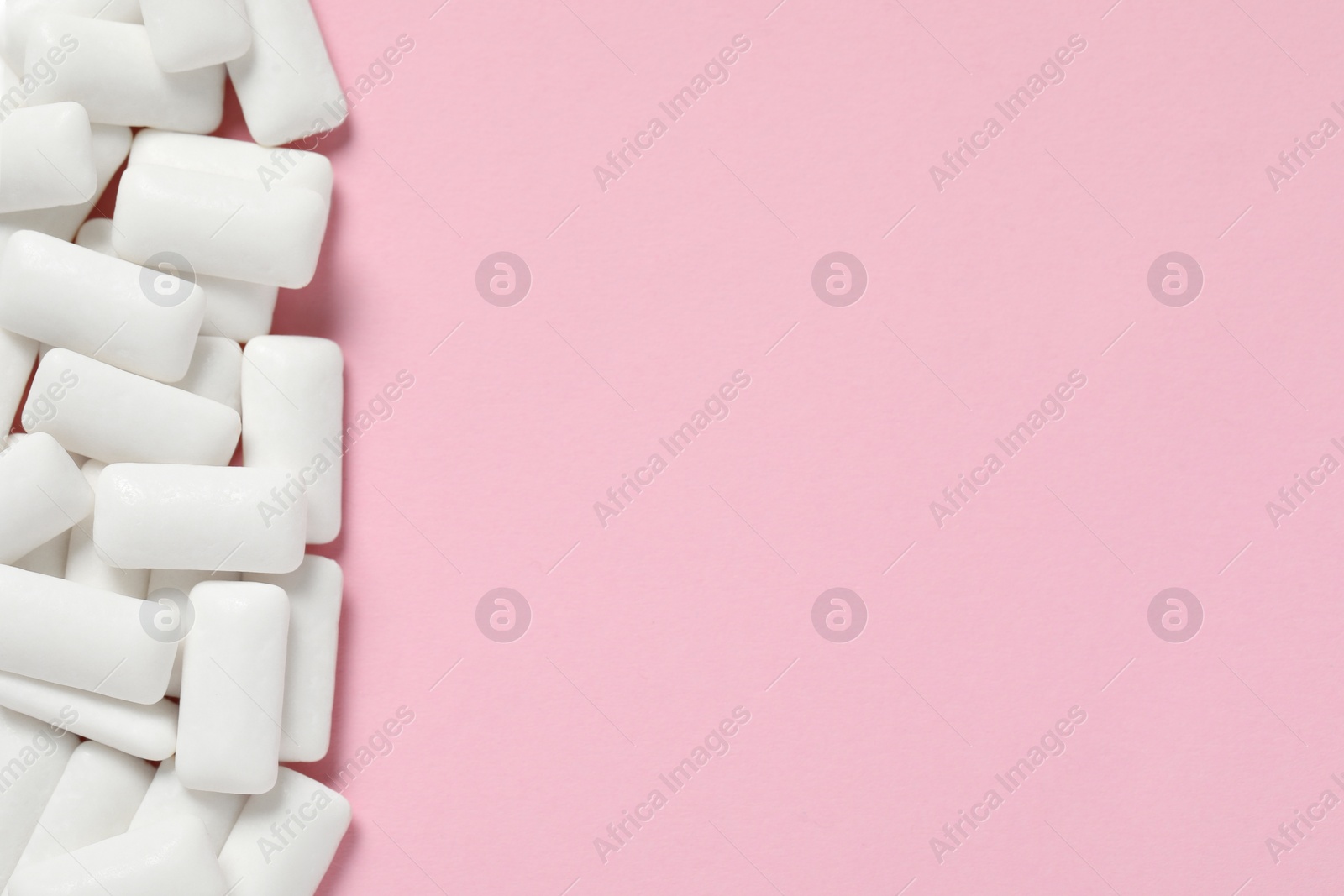 Photo of Tasty white chewing gums on pink background, flat lay. Space for text