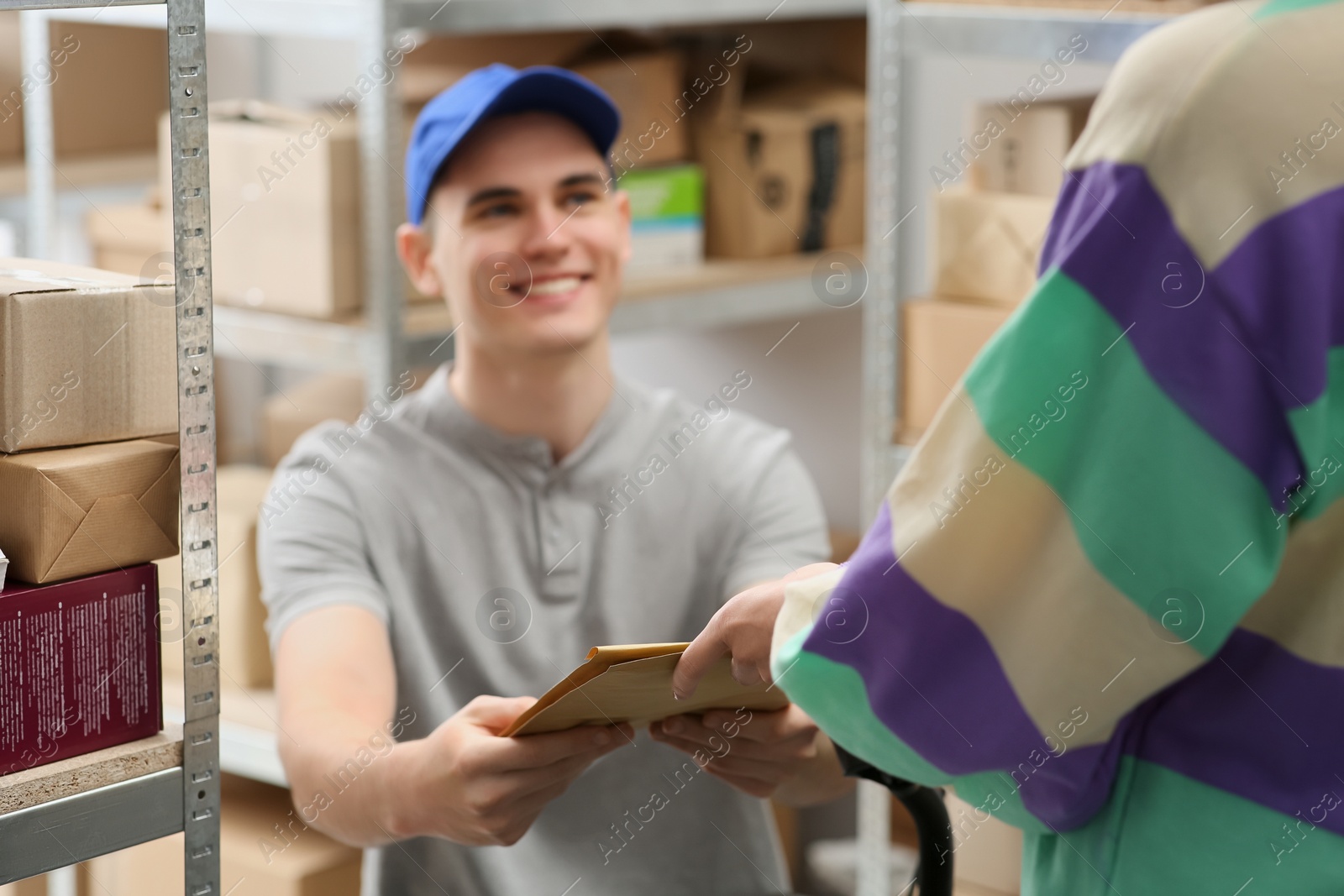 Photo of Worker giving parcel to woman at post office