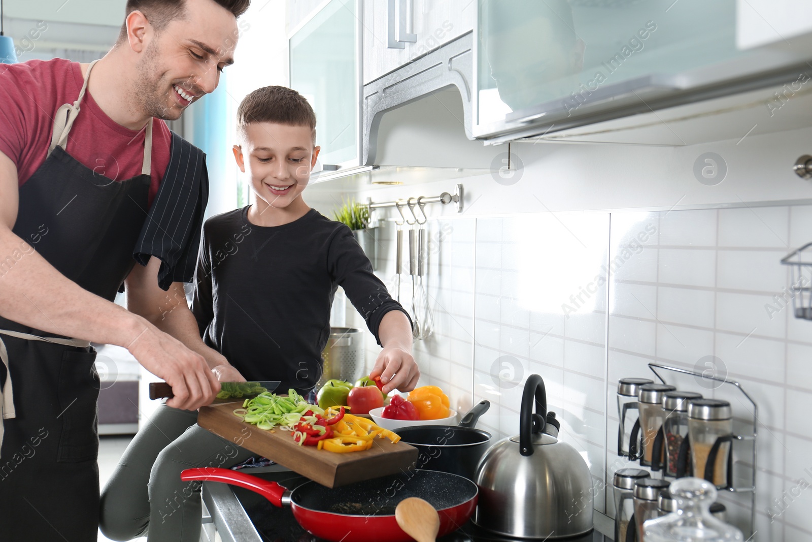 Photo of Dad and son cooking together in kitchen