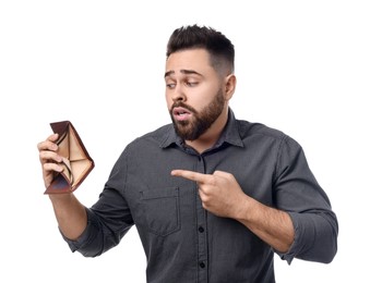 Confused man pointing at empty wallet on white background