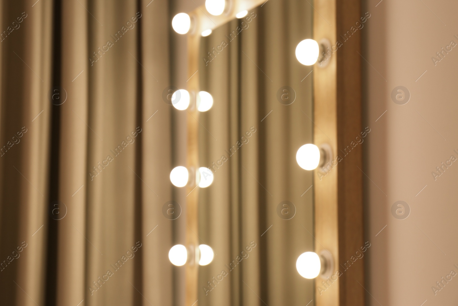 Photo of Blurred view of makeup mirror near wall in dressing room. Space for text