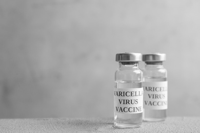 Photo of Chickenpox vaccine on grey table, space for text. Varicella virus prevention
