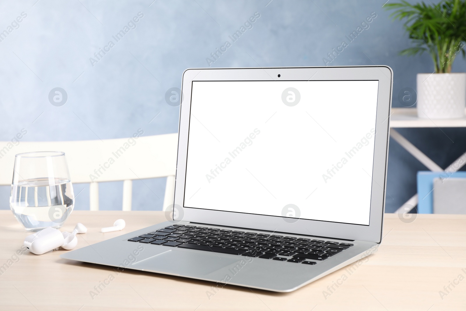 Photo of Modern laptop with blank screen on table indoors. Copy space text