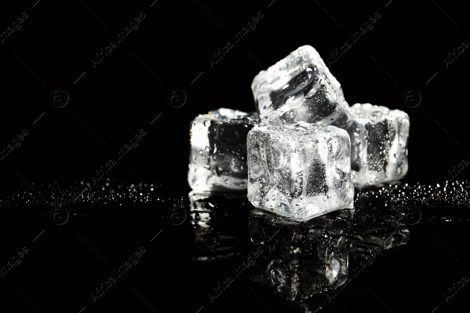 Photo of Pile of crystal clear ice cubes on black background. Space for text