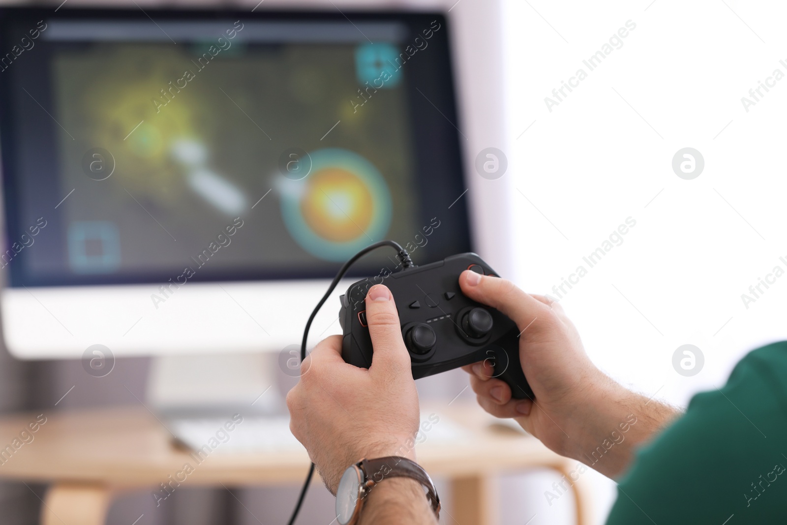 Photo of Young man playing video game at home, closeup
